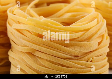 Getrocknete italienische Pasta, Fettuccinnester Stockfoto