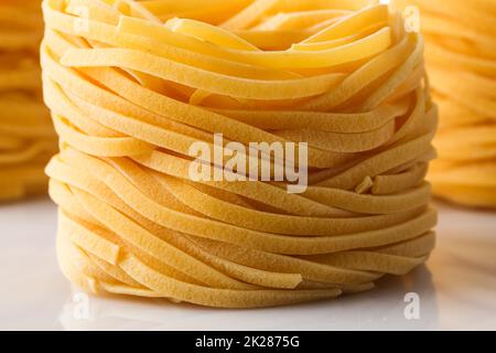 Getrocknete italienische Pasta, Fettuccinnester Stockfoto