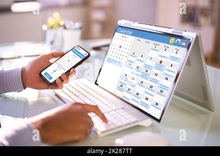 Ein Mann, Der Sich Die Monatsübersicht Im Kalender Ansieht Stockfoto