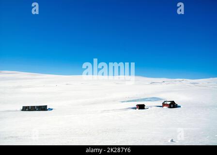 Häuser in den schneebedeckten Ebenen der Hardangervidda Stockfoto