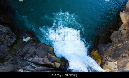 Wasserfall von oben nach unten. Draufsicht auf den Fluss, der über die Steine fließt. Wasserfall in den Rocky Mountains. Luftlandschaft Berge Felsen Wasserfall Fluss Fluss natürliche Landschaft Hintergrundbild. Stockfoto