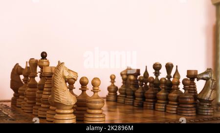 Schachbrett aus Holz mit braunen Schachstücken aus Holz. Stockfoto