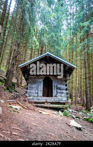 Kleine Holzkabine in einem dunklen Tannenwald Stockfoto