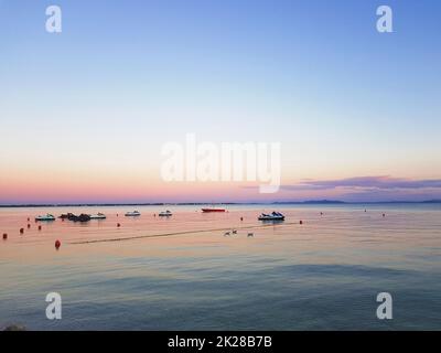 Wasserroller und kleine Boote liegen in der Bucht vor Stockfoto