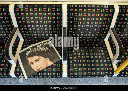 London, Großbritannien - 9. 2022. September: Eine Metro-Zeitung auf dem Sitz eines Londoner U-Bahn-Zuges in London, Großbritannien, zum Gedenken an die verstorbene Königin Elizabeth II Stockfoto