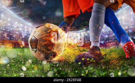 Fußballspieler mit feurigem Soccerball während des Spiels Stockfoto