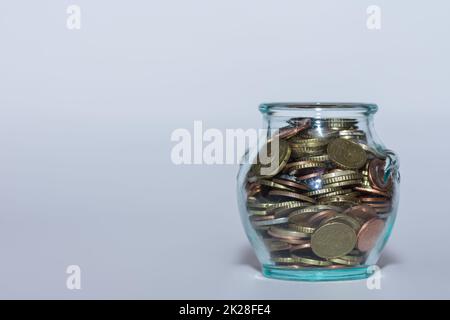 Sparte Geld in einem Glas mit vielen verschiedenen Euro-Münzen, um finanzielle Unabhängigkeit nah an Grau zu erreichen Stockfoto