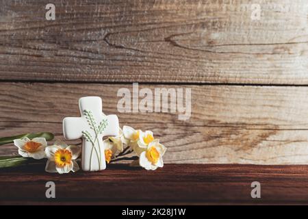 Der konzeptionelle Hintergrund der Osterferien. Cookie Cross Shape auf dem Tisch Stockfoto