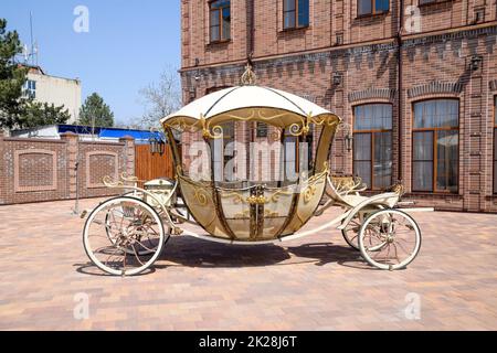 Geschmiedete Beförderung auf dem Gelände in der Nähe des Gebäudes. Schöne dekorative Coach. Stockfoto