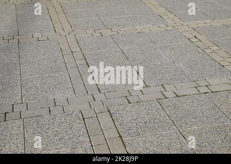 Finden Sie die Pflasterplatten im Quadrat heraus. Hintergrund von Pflasterplatten. Textur von Steinprodukten Stockfoto