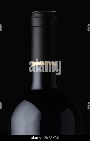 Nahaufnahme einer Flasche mit schwarzem Wein mit goldenem Verschluss Stockfoto