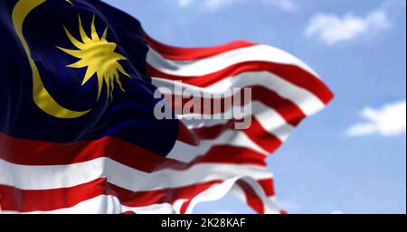 Detail der Nationalflagge Malaysias, die an einem klaren Tag im Wind winkt. Stockfoto