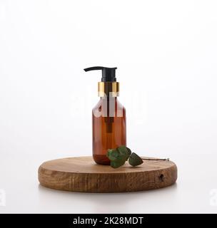 Braune Glasflasche mit schwarzer Pumpe von Kosmetikprodukten auf weißem Tisch. Natürliche Bio-Spa-Kosmetik, Beauty-Konzept Stockfoto