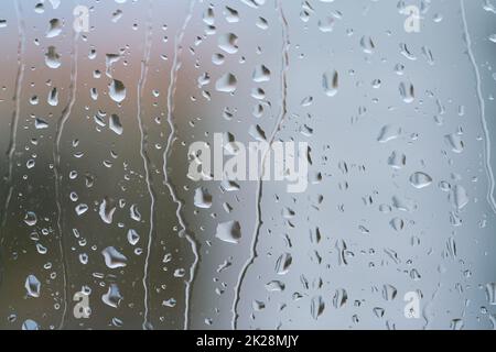 Regentropfen auf einer Fensterscheibe bei regnerischem Wetter Stockfoto