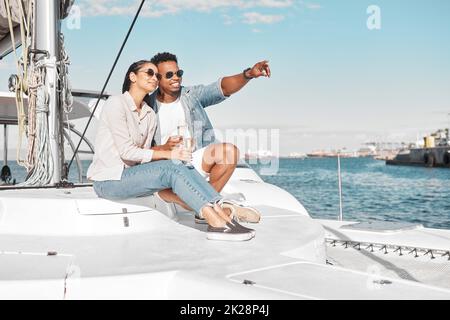 Ein Paar, eine Liebe und eine Yacht mit einem Mann und einer Frau auf dem Meer oder auf dem Meer für Romantik und ein Luxusdatum oder eine Kreuzfahrt. Glücklich, Vertrauen und Pflege mit einem jungen Stockfoto