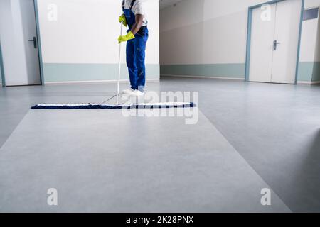 Junger Mann, Der Den Boden Mit Mopp Putzt Stockfoto