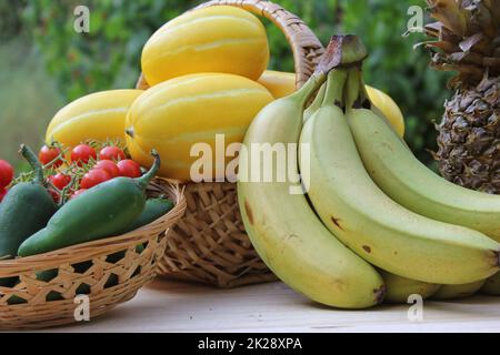 Sommer-Gemüseernte - Ginkaku koreanische Melonen mit Ananas, Bananen, Jalapeno-Paprika und Tomaten Stockfoto