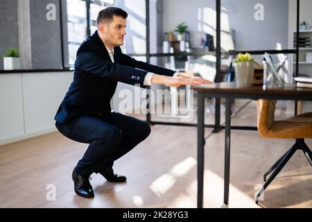 Junger Geschäftsmann, der Sit-ups macht Stockfoto