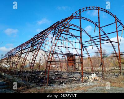 Verbrannter Hangar. Rahmen des Hangars nach dem Feuer. Alles ist abgebrannt. Stockfoto