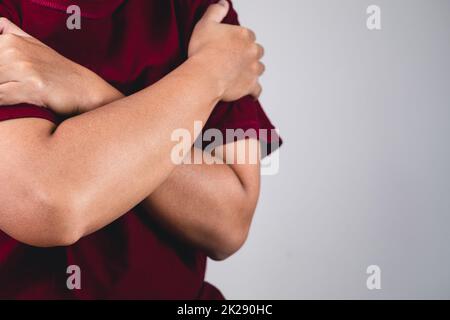 Zeichen der Selbstliebe. Umarmen Sie sich selbst und positives Denken. Der Mann mit rotem Hemd in mittlerer Nahaufnahme. Platz für Nachrichten, Wörter und Texte kopieren. Stockfoto