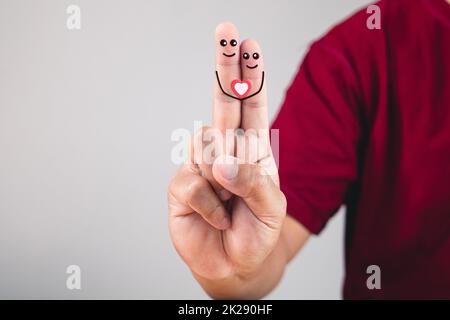 Kunst der Liebe an den Fingern. Zeigefinger und Mittelfinger sind verbunden. Valentinstag-Konzept mit Kopierplatz. Stockfoto