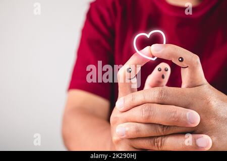 Kunst der Liebe an den Fingern. Hände verbinden sich. Kuss auf Indexspitze. Valentinstag-Konzept mit Kopierplatz. Stockfoto