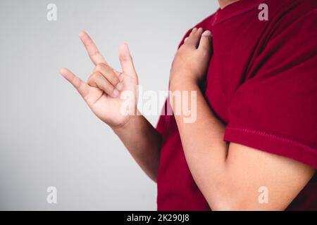 Zeichen der Selbstliebe. Umarmen Sie sich selbst und positives Denken. Der Mann mit rotem Hemd in mittlerer Nahaufnahme. Platz für Nachrichten, Wörter und Texte kopieren. Stockfoto