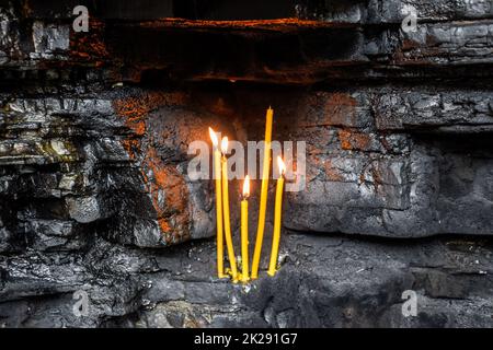 Wachs Kirche Kerzen in Rock Nischen. Heiligen Ort Stockfoto