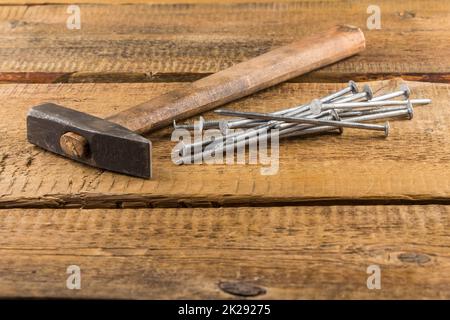 Vintage Hammer mit Nägeln auf Holz Hintergrund Stockfoto