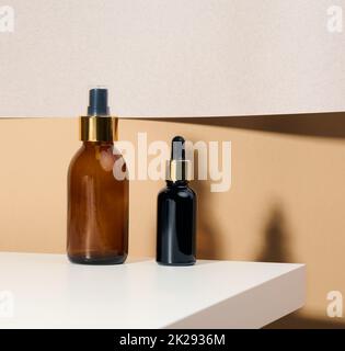 Braune Glasflasche mit Pipette steht auf einem weißen Tisch. Kosmetik-SPA-Branding. Verpackung für Gel, Serum, Werbung und Produktwerbung, Mock Up Stockfoto