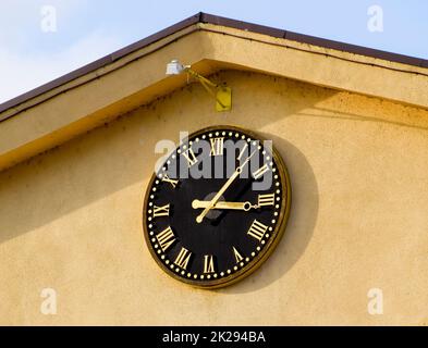 Uhr mit römischen Ziffern auf der Vorderseite des Hauses Ziffernblatt Stockfoto