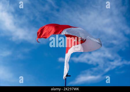 Flagge fliegt an einem Sommertag in Bayern gegen einen blau-weißen Himmel Stockfoto