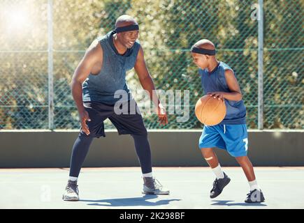 Sport, Familie und Basketball lernen mit einem Vater und einem Sohn trainieren auf einem Platz draußen für Freizeit Fitness und Spaß. Schwarzer Mann und Kind tun Übung und Stockfoto