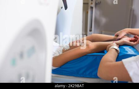 Hübsche, junge Frau, die eine computerisierte axiale Tomographie (CAT) durchläuft Scan medizinische Untersuchung/Untersuchung in einem modernen Krankenhaus (farbiges Bild, flacher DOF) Stockfoto