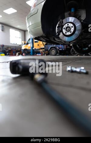 Fahrzeug in einer Garage für Wartung, Öl-/Reifenwechsel (flaches Bild mit DOF-Farbtönen) Stockfoto