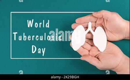 Der Welt-Tuberkulose-Tag steht auf dem Papier, die Hände halten eine Lunge, das Bewusstsein für Krankheiten, die Gesundheitsversorgung Stockfoto