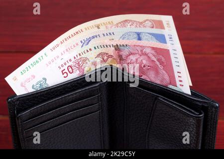 Altes südafrikanisches Geld in der schwarzen Brieftasche. Stockfoto