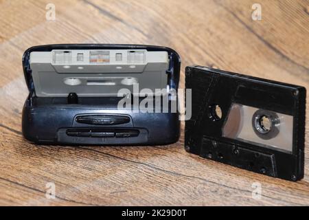 Retro-Audiokassetten neben einem tragbaren Player zum Abspielen von kompakten Kassetten. Stockfoto