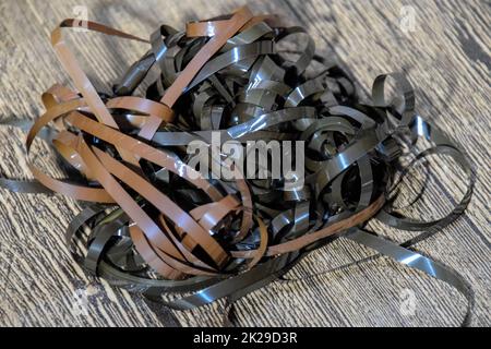 Audiofilm auf dem Tisch. Ein Magnetfilm aus einer zerbrochenen Kassette. Stockfoto