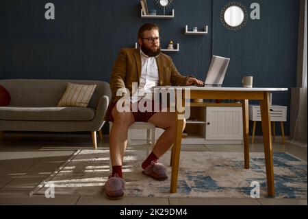 Fokussierter intelligenter Kerl Geek Experte, der online arbeitet Stockfoto