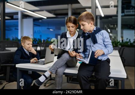 Kleine Kinder Mitarbeiter diskutieren Projekt im Büro Stockfoto