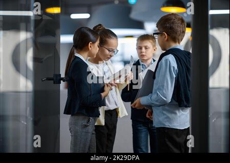 Das Business-Team der Kinder diskutiert die Arbeit im Büro Stockfoto