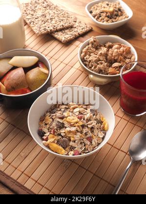 Reichhaltiges Frühstück mit Bio-Cerealien und Zutaten auf einem Holztisch Stockfoto