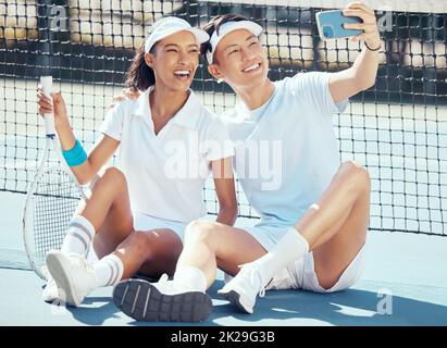 Selfie, Sport oder Paar, die auf einem Tennisplatz sitzen und sich nach dem Training, Training oder Training ausruhen. Wellness, Fitness oder Gesundheit mit einem interrassischen Mann Stockfoto