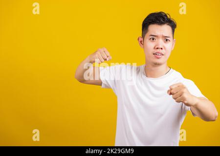 Ein junger wütender Mann, der einen Schlag zeigt, drückt die Faust Stockfoto