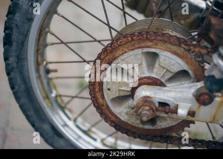 Nahaufnahme einer rostigen Motorradübertragungskette. Stockfoto