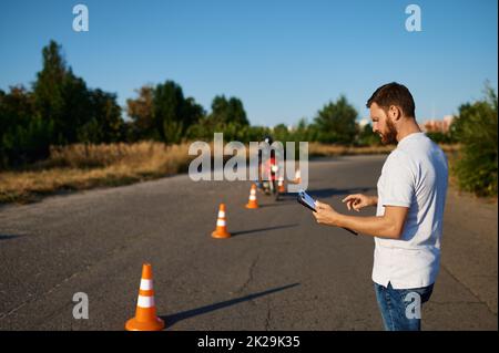 Schüler fährt um die Kegel, Motorradschule Stockfoto
