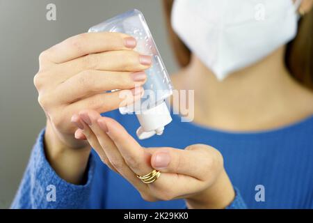Nahaufnahme Frau, die die Hand mit Desinfektionsmittel-Alkohol-Gel desinfiziert Stockfoto