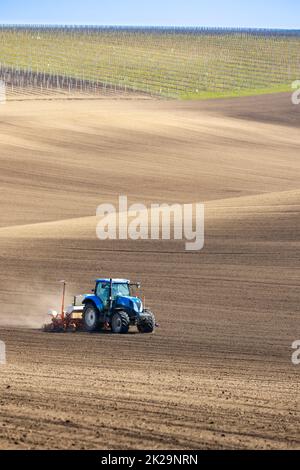 Traktor mit Saatbohrer in der frühen Frühlingslandschaft Stockfoto