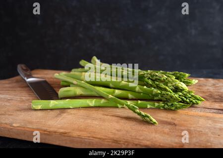 Frischer grüner Spargel auf Holzbrett Stockfoto